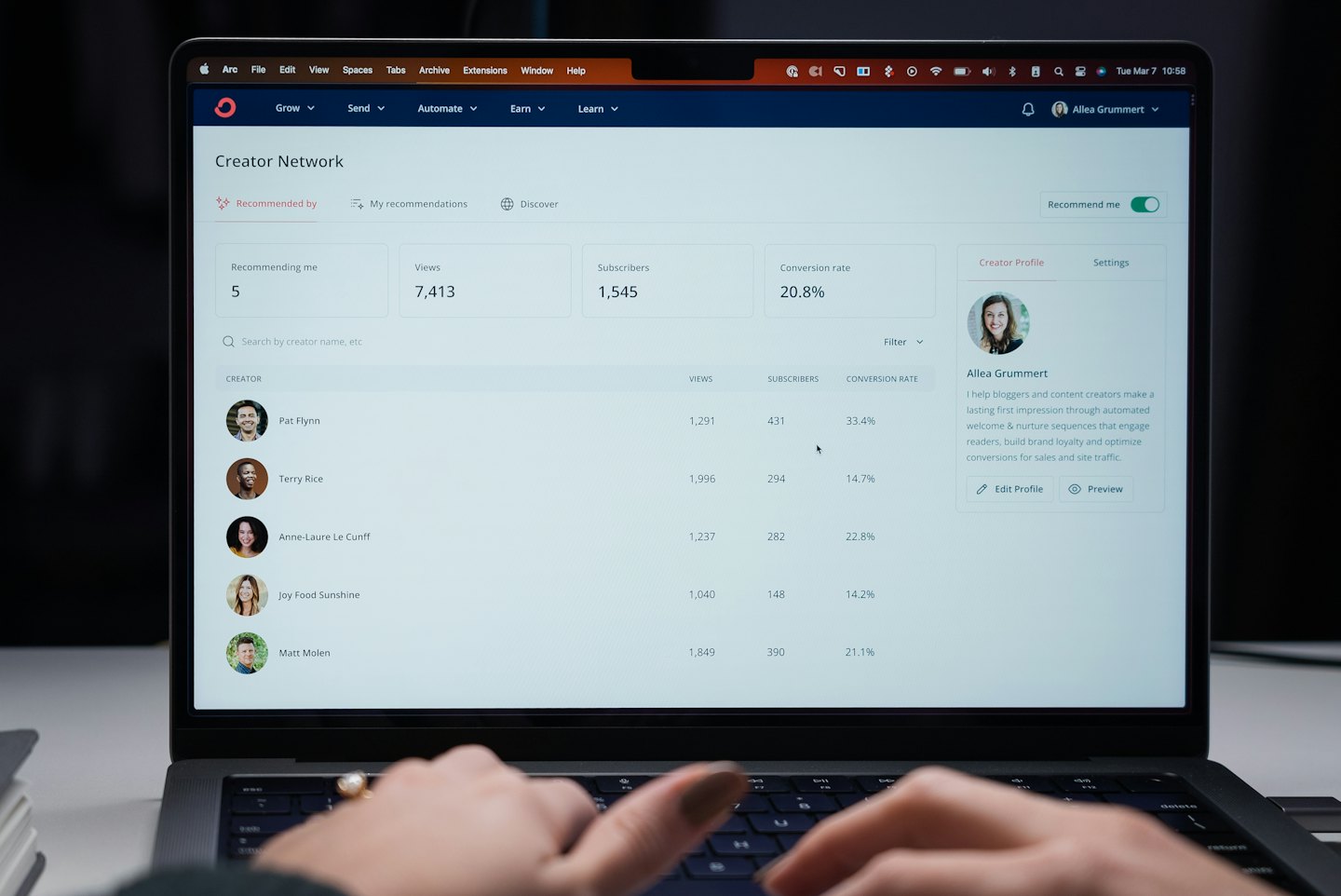 Mani che digitano su un laptop che mostra metriche della rete di creator.