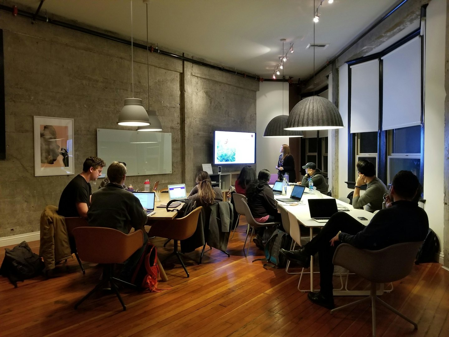 Professionisti collaborano attorno a tavoli in una moderna sala riunioni.