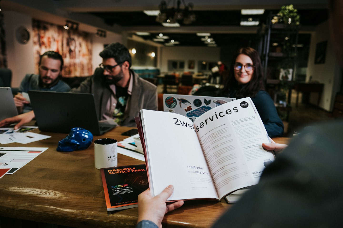 Professionisti che collaborano attorno a un tavolo con una brochure.